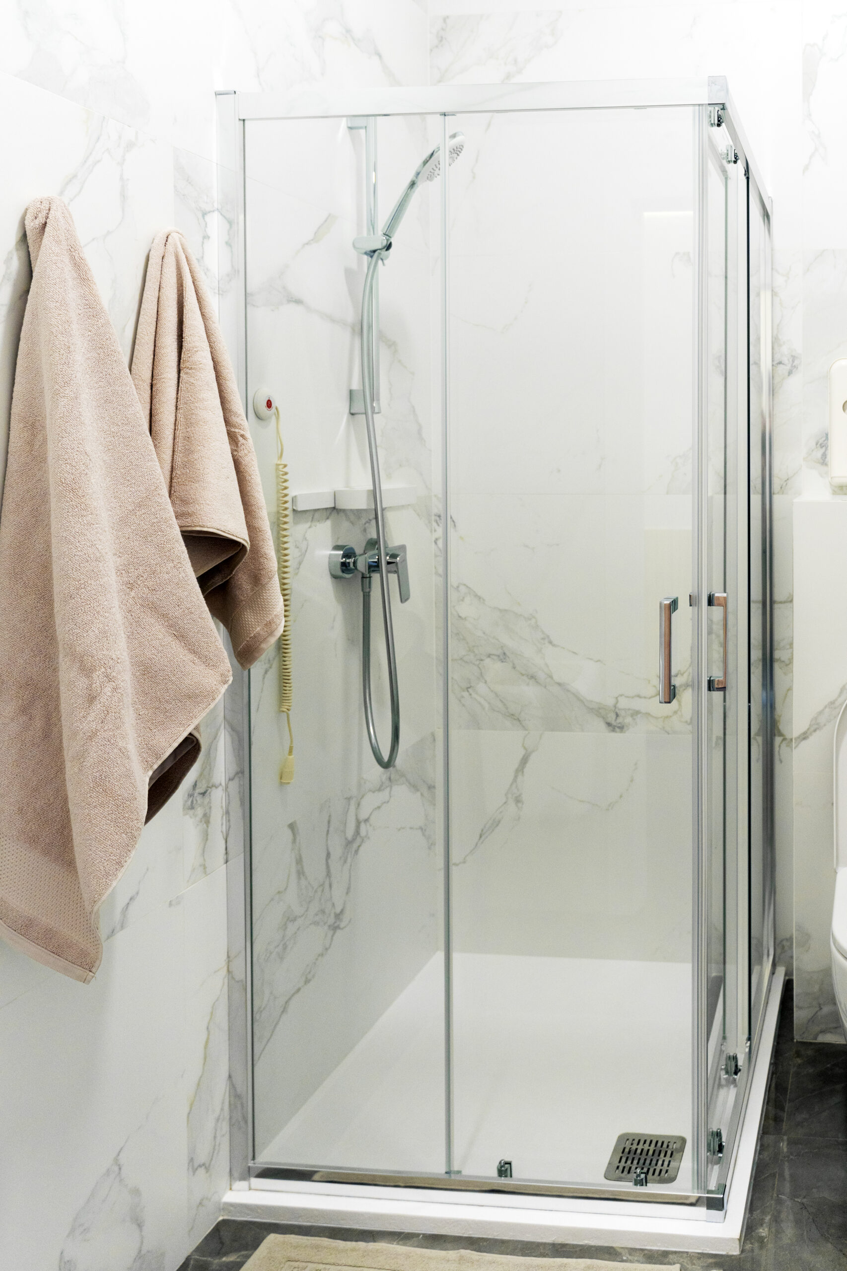 Baño moderno limpio con plato de ducha instalado y mampara de cristal